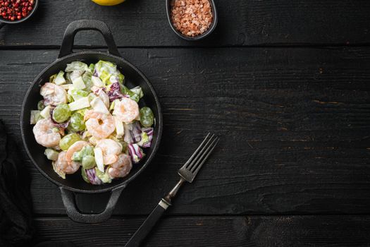 Healthy food concept, Diet salad plate. Fresh seafood salad with prawns or shrimp set , with sauce apple and grape, on black wooden table, top view flat lay, with copy space for text