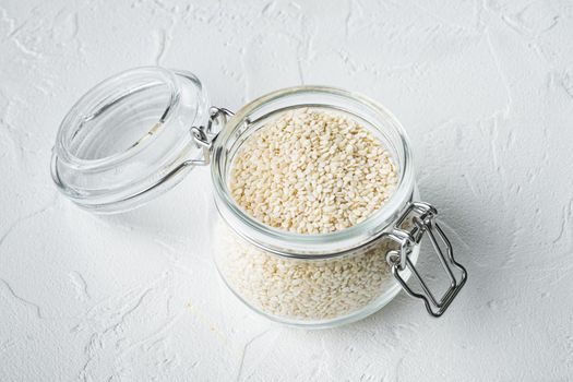Organic natural sesame seeds set, in glass jar, on white stone background