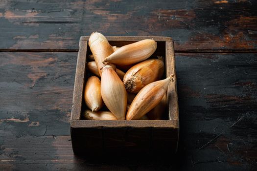 Raw whole baby shallot onion, on old wooden table