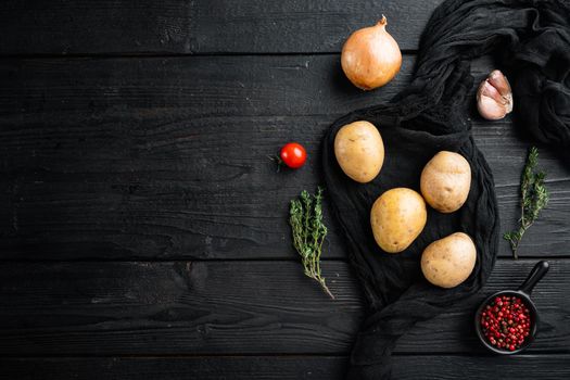 Fresh Pile of potatoes set, on black wooden table background, top view flat lay , with space for text copyspace
