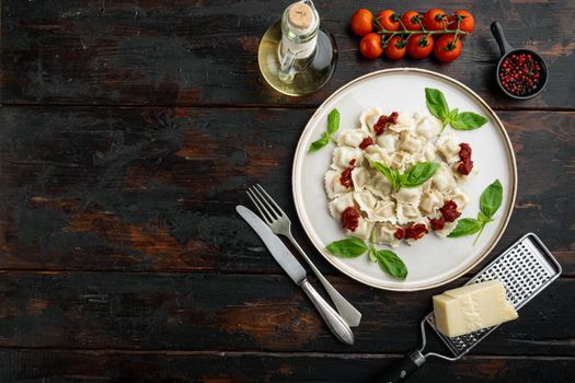 Ravioli pasta with mushroom cream sauce and cheese - Italian food style set with basil parmesan and tomatoe on white plate on old dark wooden table background, top view flat lay , with copyspace and space for text