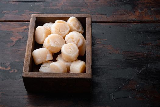 Fresh seafood, scallops meat, on dark wooden background with space for text
