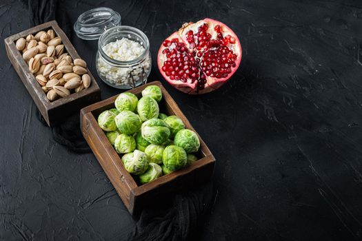 Brussels sprouts with pomegranate, cottage cheese and pistachios, on black textured background with space for text