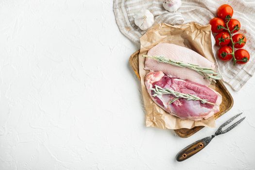 Raw duck breast set, with herbs and ingredients, on wooden tray, on white stone background, top view flat lay, with copyspace and space for text
