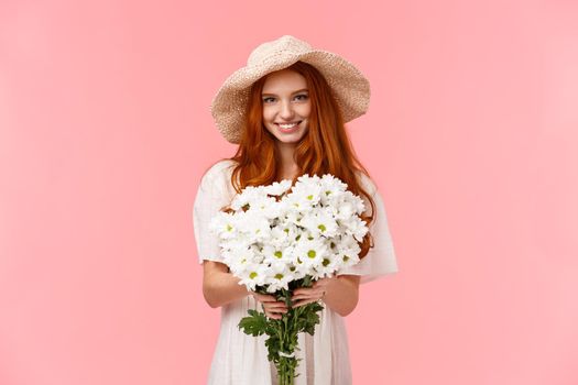 Its for you, congratulations. Alluring lovely young charismatic redhead girl giving bouquet of white flowers and smiling, congrats with birthday, express love and care, standing pink background.