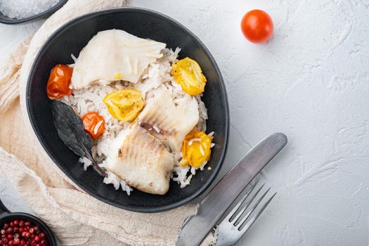 Tilapia fish with basmati rice and cherry tomatoes, in bowl, on white background, top view with copy space for text