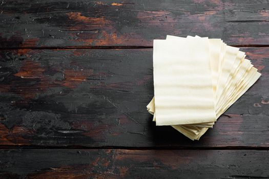 Lasagna dough sheets set, on old dark wooden table background, with copy space for text