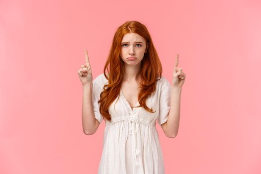 Silly upset, timid and insecure pouting redhead girl, looking camera gloomy with sulking whining expression, pointing fingers up with regret or jealousy, asking for something, begging hopeful.