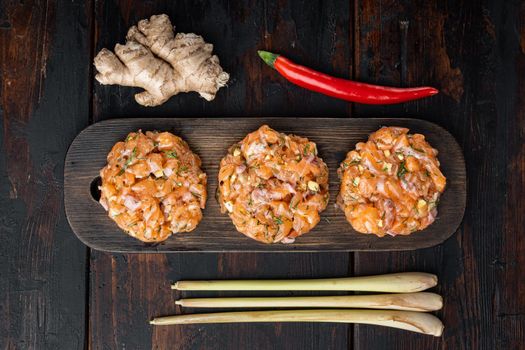 Quick asian raw fish patties with herb, on old wooden table, flat lay