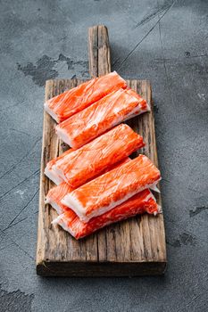 Crab sticks seafood semi finished fish mince with blue swimming crab set, on wooden cutting board, on gray background