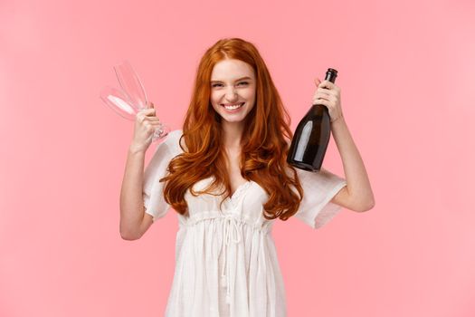 Woman celebrating signing big contract at work, congrats friend, holding two glasses and champage, drinking for success, feeling amused and joyful, triumphing achievement, pink background.