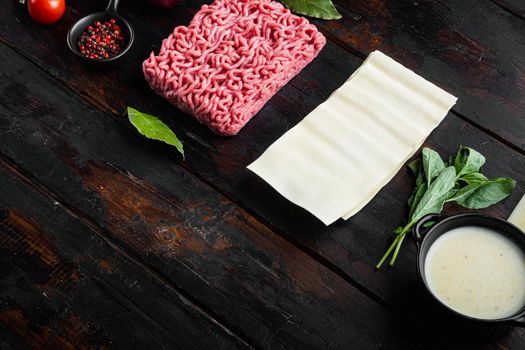 Ingredients for making traditional lasagna. Mince, pasta, cheese, tomatoes, Bechamel set, on old dark wooden table background, with copy space for text