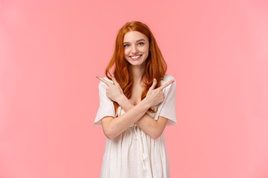 Waist-up portrait lovely feminine, sensual redhead woman in white dress, asking your opinion, showing two variants, cross hands over body and pointing left and right banners, smiling friendly.