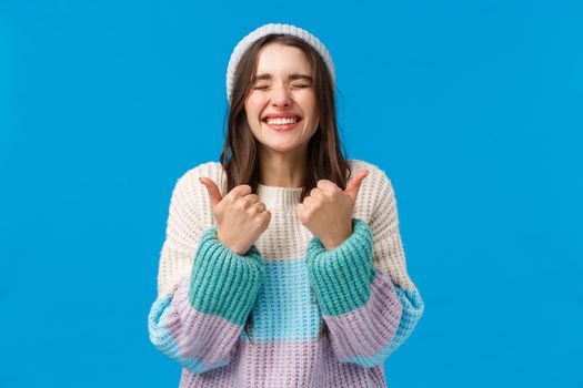 Happy and cheerful carefree cute brunette girl received awesome present, dream came true on christmas, new year, smiling and showing thumb-up close eyes cant believe so lucky, like super cool gift.