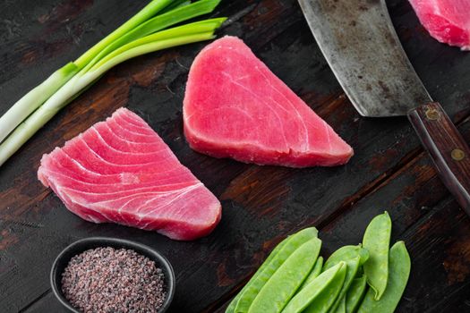 Tuna fish fillet raw organic steak with ingredients set, and old butcher cleaver knife, on old dark wooden table background
