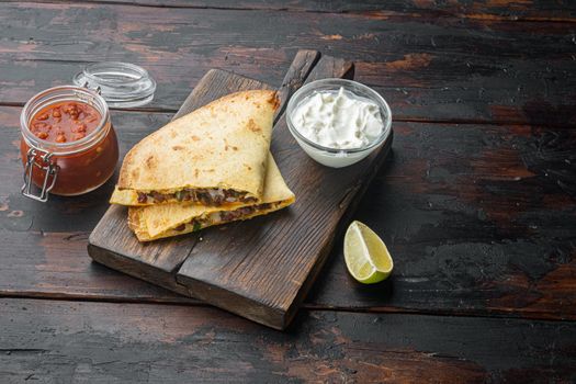 Quesadilla with chicken, cheese and vegetable, on old dark wooden table background with copy space for text