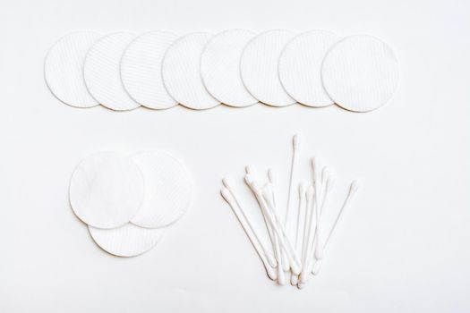 Clean cotton pads and cotton swabs for removing cosmetics on a white background. Top view