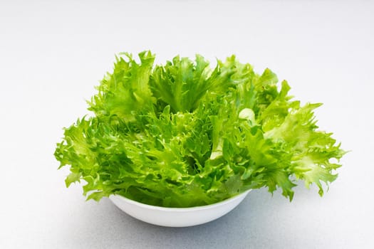 Fresh green lettuce leaves in a bowl on the table. Healthy eating