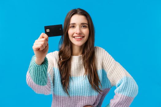 Best bank for young generation. Attractive pleased charismatic young woman in winter sweater, showing credit card and smiling satisfied, recommend financial system, new banking features.
