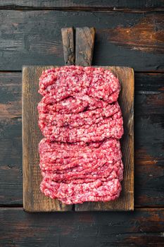 Raw minced fresh meat, on old dark wooden table background, top view flat lay