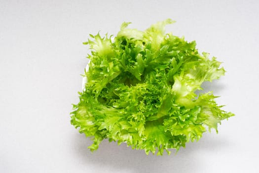 Fresh green lettuce leaves in a bowl on the table. Healthy eating. Top view