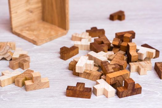 Organization and order. The wooden pieces of the puzzle lie in a mess next to the folding mold
