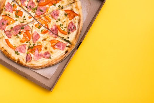 Takeaway and delivery. Ready-to-eat pizza in cardboard box on yellow background