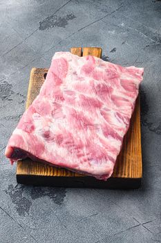 Pork rib set, on wooden cutting board, on gray stone background
