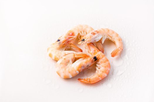 Raw thawed prawns with water drops on a pink background. Mediterranean food