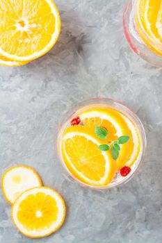 Hard seltzer cocktail with orange, cranberry and mint in glasses on the table. Alcoholic highly carbonated drink. Vertical and top view