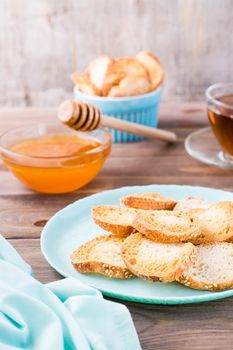 Small baguette toast on a plate on a wooden table. Vertical view