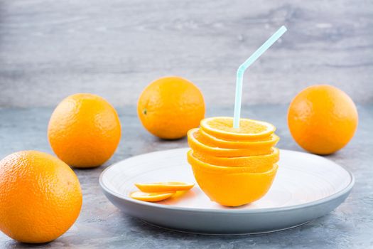 Fresh orange slices in a stack and a straw for a drink. Simulated orange juice
