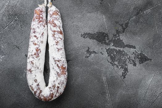 Dry cure salami sausage fuet on grey background, topview with space for text.