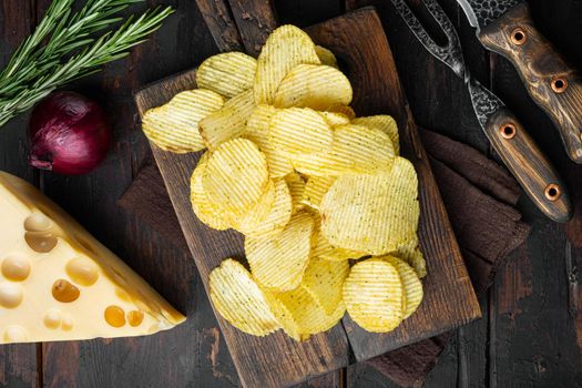 Crispy potato chips set, on old dark wooden table, top view flat lay