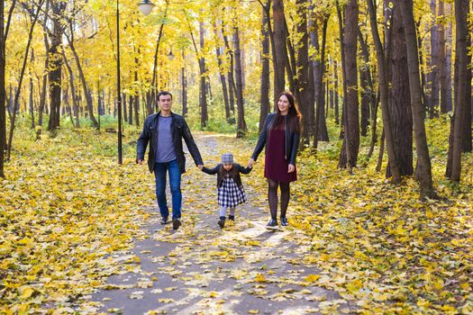 Parenthood, fall and people concept - young family happy in autumn park.