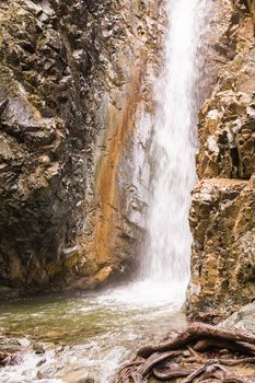 Autumn waterfall with rocks and leaves in Troodos mountains in Cyprus.