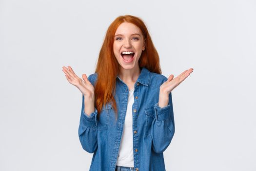 Cheerful, happy and optimistic alluring redhead teenage girl clap hands and laughing from amazement, having fun, enjoy watching funny stand-up comedy performance, white background.