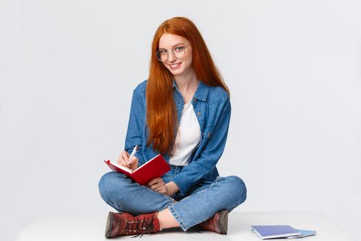 Dreamy and creative, talented female writer, student want become journalist, taking notes, to-do list, writing something in notebook and looking sassy camera, sligtly smiling.