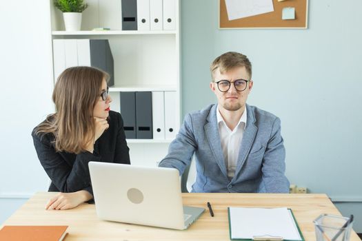 Business, emotions and people concept - Two angry and exhausted workers at working place. People wearing the packages on their heads with pictured emotions.