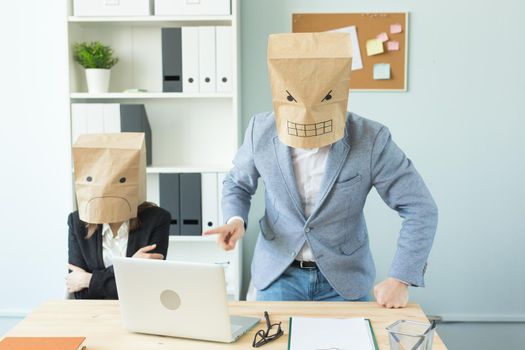 Business, emotions and people concept - Two angry and exhausted workers at working place. People wearing the packages on their heads with pictured emotions.