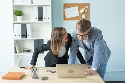 Business and people concept - Portrait of man and woman discussing project in office.