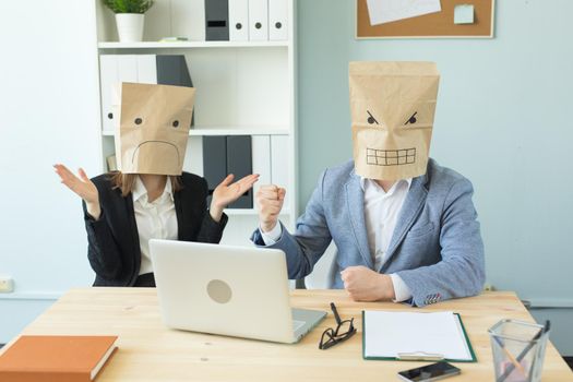 Business, emotions and people concept - Two angry and exhausted workers at working place. People wearing the packages on their heads with pictured emotions.