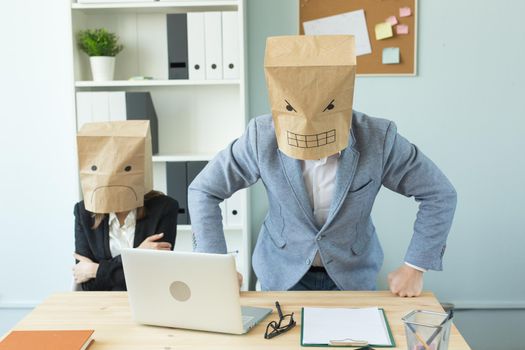 Business, emotions and people concept - Two angry and exhausted workers at working place. People wearing the packages on their heads with pictured emotions.