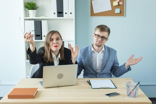 Business and people concept - Portrait of man and woman discussing project in office.