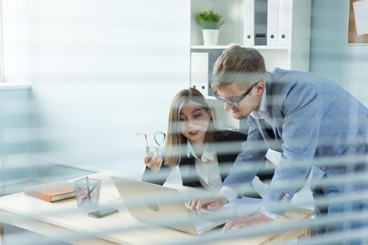 Business and people concept - Portrait of man and woman discussing project in office.