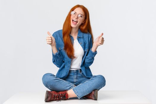 Yeah go for it. Excited and sassy good-looking assertive redhead teenage girl with red foxy haircut, sitting crossed legs on floor, showing thumbs-up and saying yes, recommend, approve something.