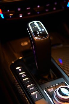 Automatic gear stick of a modern car, multimedia and navigation control buttons. Car interior details. Transmission shift. Shallow dof.