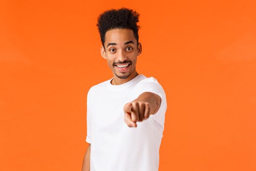 We need you, hired. Cheerful and assertive african-american guy making his final choice, decide, found excellent candidate, pointing camera inviting to work together, smiling, orange background.