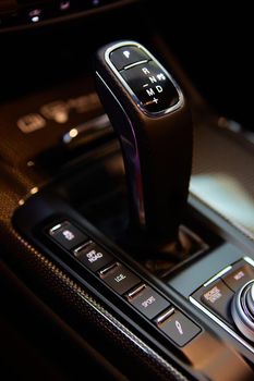 Automatic gear stick of a modern car, multimedia and navigation control buttons. Car interior details. Transmission shift. Shallow dof.
