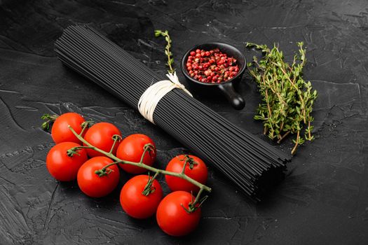 Squid ink black pasta with ingredients set, on black dark stone table background